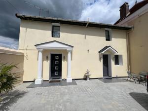 a white building with a black door and a patio at Kings Villa near Disneyland reserved only for family with kids in Saint-Germain-sur-Morin
