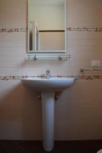 ein Badezimmer mit einem weißen Waschbecken und einem Spiegel in der Unterkunft Vacanze Morfino in Castelluzzo