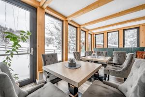 ein Esszimmer mit Tischen, Stühlen und Fenstern in der Unterkunft Landhaus Edelweiss in Sankt Leonhard im Pitztal