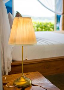 a lamp sitting on a table next to a bed at Cadlao Resort and Restaurant in El Nido