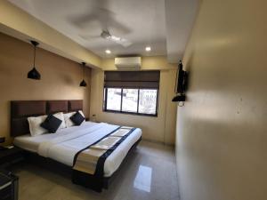 a bedroom with a large bed with a window at The Fountain Inn - Fort in Mumbai
