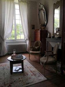 uma sala de estar com uma mesa e cadeiras e um espelho em Chambre aux coccinelles em Cosne-Cours-sur-Loire