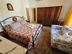 um quarto com uma cama, um sofá e uma cadeira em a casa di Gabri em Montefollonico