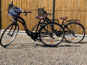 deux vélos garés l'un à côté de l'autre devant un bâtiment dans l'établissement Le Jardin 51, à Andernos-les-Bains