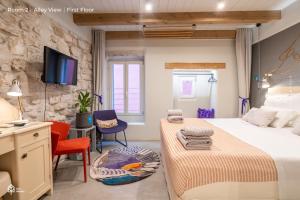 sypialnia z 2 łóżkami, biurkiem i telewizorem w obiekcie Casa Amando Eco Boutique House w Rovinj