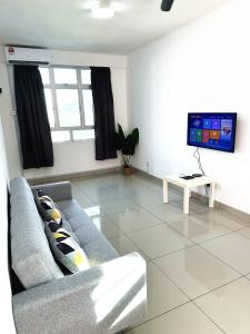 ein Wohnzimmer mit einem Sofa und einem TV in der Unterkunft TuR10-Oppesite Pisa Stadium-1min-FoodCourt-MiniMarket in Bayan Lepas