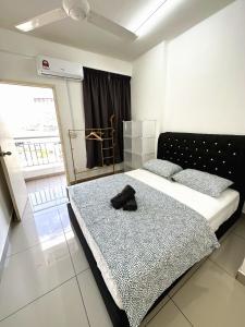 ein Schlafzimmer mit einem Bett mit einem Paar Schuhe darauf in der Unterkunft TuR10-Oppesite Pisa Stadium-1min-FoodCourt-MiniMarket in Bayan Lepas