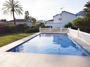einen Pool im Hinterhof mit einem weißen Zaun in der Unterkunft Villa Marbella in Marbella