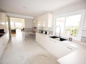 eine Küche mit weißen Schränken und einem großen Fenster in der Unterkunft Villa Marbella in Marbella