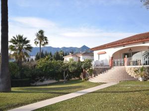 una casa con escaleras, palmeras y montañas en Villa Marbella, en Marbella