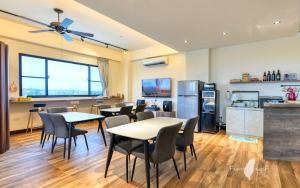 una habitación con mesas y sillas y una cocina en 漫活時光民宿 Leisure Living en Baisha