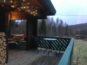 porche con mesa y sillas en la cubierta en Log Cabin, forrest , sea view, north Sweden., en Luleå