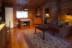 uma sala de estar com um sofá e uma mesa em Log Cabin, forrest , sea view, north Sweden. em Luleå