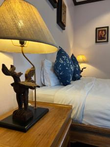 um quarto com uma cama e um candeeiro sobre uma mesa em Pha Thai House em Chiang Mai