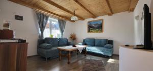 a living room with two blue couches and a table at Appartement Claudia in Going am Wilden Kaiser
