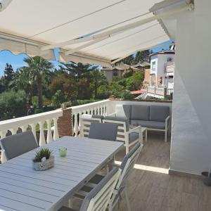 a wooden table and chairs on a deck with an umbrella at Villa Calahonda - Mijas in Mijas