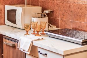eine Küchentheke mit drei Weingläsern und einer Mikrowelle in der Unterkunft Gothic Apartments by Wonderful Italy in Bellagio
