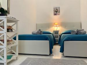 een slaapkamer met twee bedden met blauwe lakens en een plank bij I Limoni del Sud Sardegna in Assemini