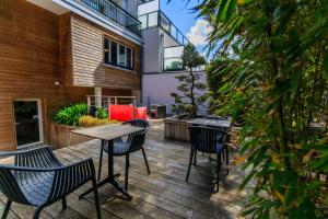 un patio avec des chaises et une table sur une terrasse dans l'établissement Best Western Hôtel Garden and Spa, à La Baule