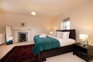 a bedroom with a large bed and a fireplace at JOIVY Observatory House and Apartment in Edinburgh