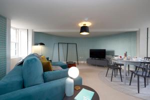 a living room with a blue couch and a table at JOIVY Observatory Unique House on Calton Hill in Edinburgh