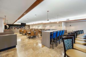 a restaurant with blue chairs and tables in a room at Best Western Plus Henderson Hotel in Las Vegas