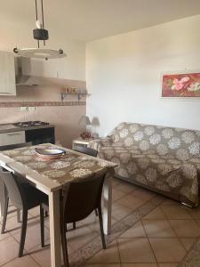 cocina y sala de estar con mesa y sofá en Lampedusa Vi attende en Lampedusa