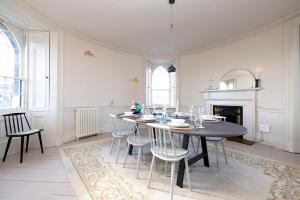 a dining room with a table and chairs and a fireplace at JOIVY Observatory House and Apartment in Edinburgh
