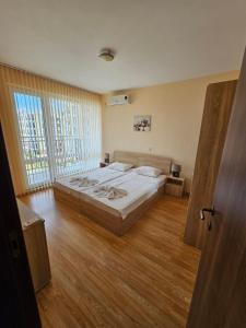 a bedroom with a large bed and a large window at Oxygen Apartments in Sveti Vlas