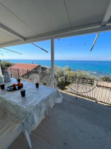 a table on a porch with a view of the ocean at Elia’s house in Ligia