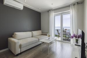 a living room with a white couch and a table at Apartmani Stipe Brela in Brela