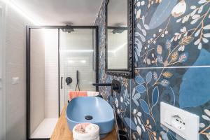 a bathroom with a blue sink and a mirror at La casa di Susy in Avola +15 photos