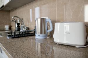 eine Kaffeemaschine und ein Toaster auf einer Küchentheke in der Unterkunft Cabo do Mar Apart- Azul Beach in Espinho