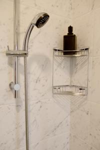 a shower with a shower head and a soap dispenser at Cabo do Mar Apart- Azul Beach in Espinho