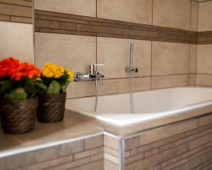 eine weiße Badewanne mit Blumen im Bad in der Unterkunft Like Home Apartment in Reggio di Calabria