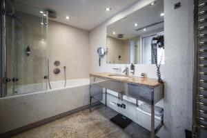 uma casa de banho com um lavatório, um chuveiro e uma banheira em Rysy Boutique Hotel em Zakopane
