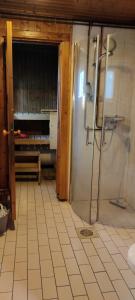 a bathroom with a shower and a tiled floor at Punainen tupa in Kalajoki