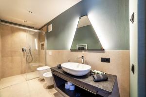 bagno con lavandino e doccia di Aktiv Lodge Meran - Terrace Large a Saltusio