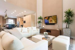 uma sala de estar com mobiliário branco e uma televisão de ecrã plano em Magic Village Yards Trademark Collection by Wyndham em Orlando