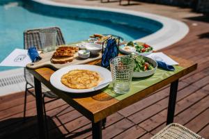 a table with food on it next to a pool at SECRET HILL in Athanion