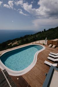 una piscina su una terrazza con vista sull'oceano sullo sfondo di SECRET HILL a Athanion