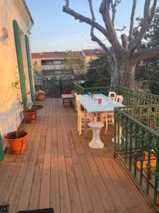 a patio with a table and chairs and a tree at Nice flat terrace big garden 10min beach'n'center in Argelès-sur-Mer