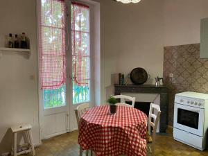 a kitchen with a table with a red and white table cloth at Nice flat terrace big garden 10min beach'n'center in Argelès-sur-Mer
