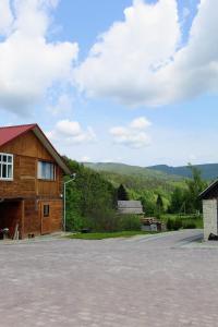 een schuur en een huis met bergen op de achtergrond bij Садиба "У Бервінових" in Jaremtsje