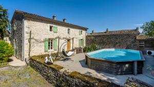 a house with a swimming pool in front of a building at O 4 SAISONS DE BREILBON in Germond