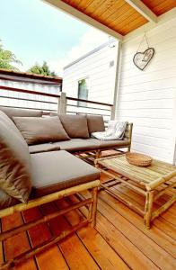 un sofá y una mesa de centro en una terraza en Mylooking vacanze Porlezza, en Porlezza