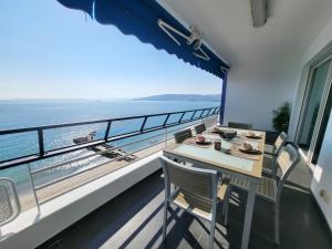 a balcony with a table and chairs and the ocean at LE COLOMBIER T3 VUE MER PANORAMIQUE in Antibes