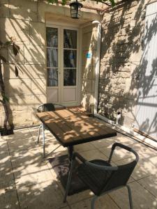 einen Tisch und einen Stuhl vor einer Tür in der Unterkunft Château Catherine de Montgolfier B&B in Narbonne