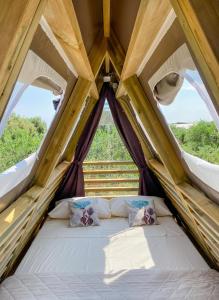 Bett in einem Zelt mit zwei Kissen in der Unterkunft A-luxury Glamping by La Mignola in Fasano