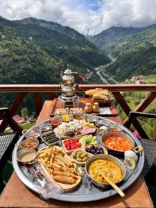 uma mesa com uma bandeja de comida numa mesa com montanhas em Zifona Bungalov em Çamlıhemşin